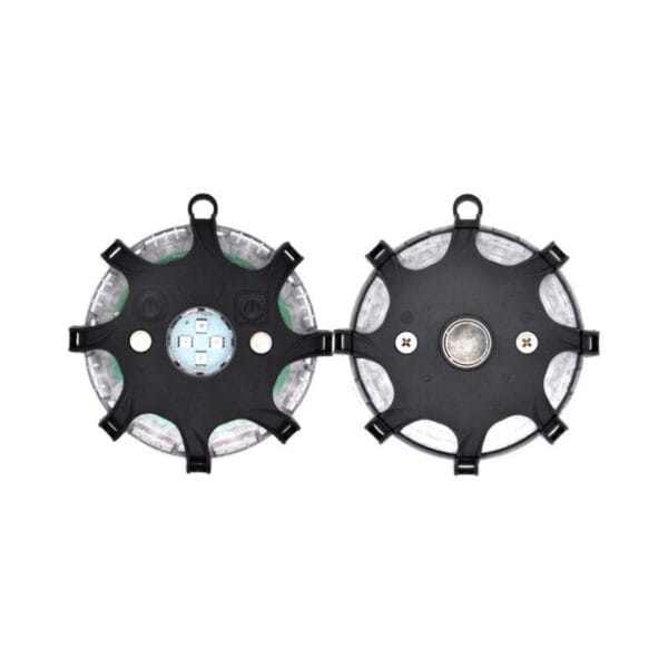 Two circular black-plastic devices with securing loops, shown top and bottom, revealing internal components through clear sections.