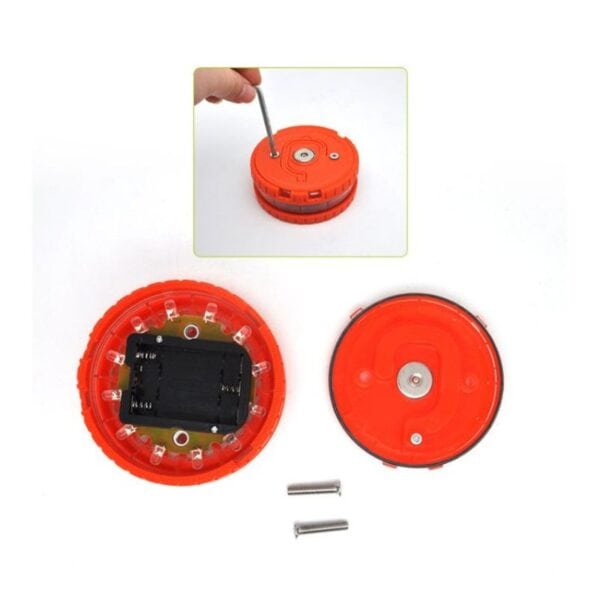 A disassembled red circular electronic device with exposed circuitry, removed back cover and screws, along with a hand using a screwdriver.