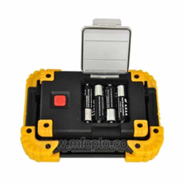 An open black and yellow battery case with a gray lid, showing three AA batteries inside.