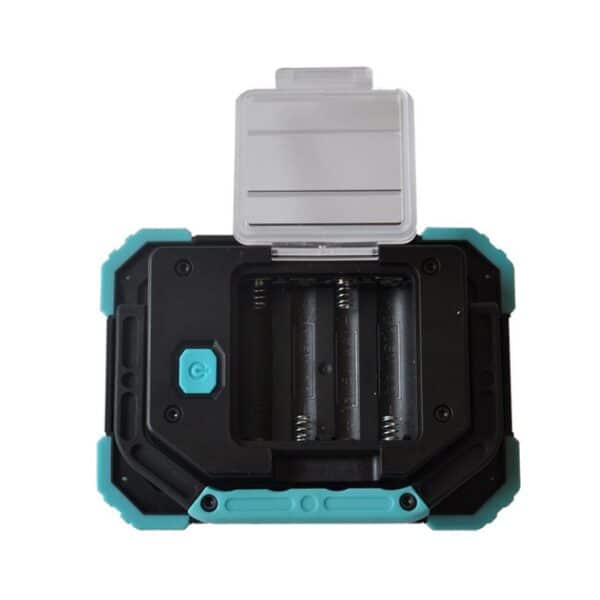 A black and teal electronic device with an open battery compartment and a transparent hinged cover.
