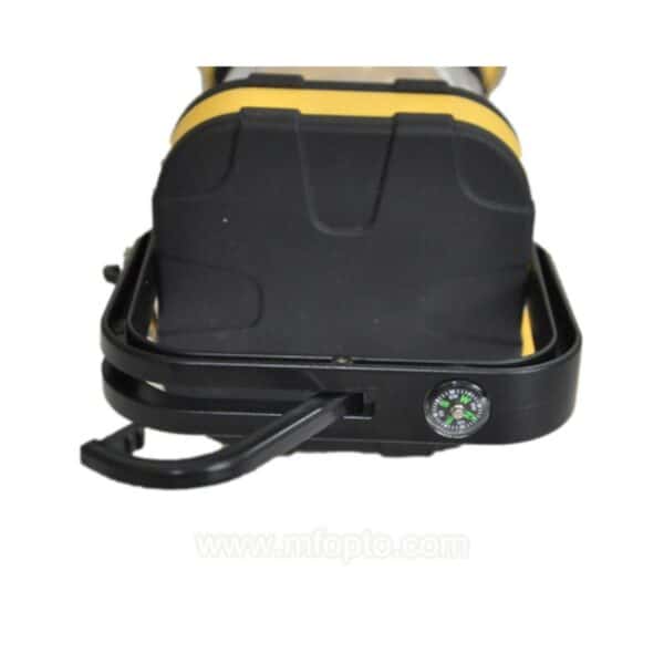 Close-up of a black and yellow portable device showing the compass and handle.