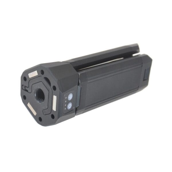 A compact black device with a lens, control buttons on one end, and two extending metal prongs.