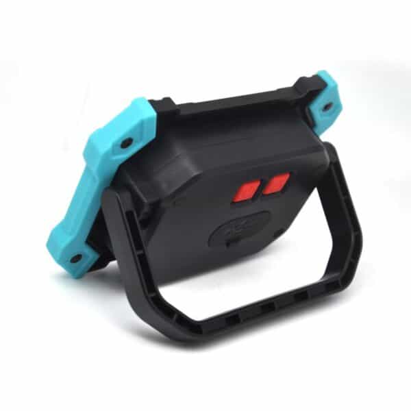 A black and turquoise handheld device with a grip and two front red buttons, viewed from an angle.