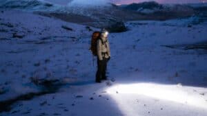 man using headlamp in snow field