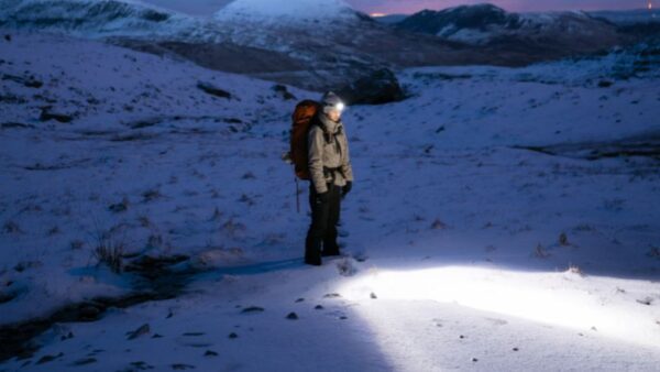 man using headlamp in snow field