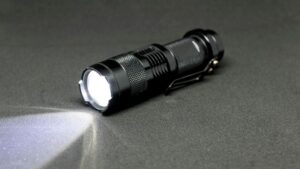 Bright LED flashlight emitting powerful beam on dark surface for outdoor or emergency use.