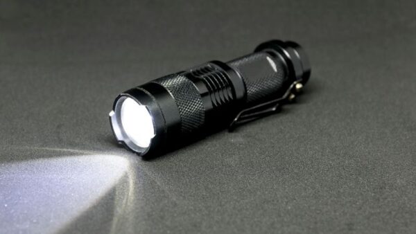 Bright LED flashlight emitting powerful beam on dark surface for outdoor or emergency use.