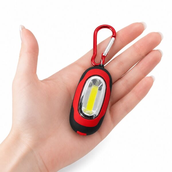 WK1040 mini COB keychain flashlight shown in a hand to demonstrate its compact size.